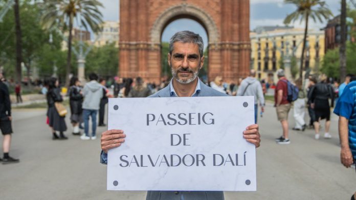 El concejal de Vox en el Ayuntamiento de Barcelona, Gonzalo de Oro, posa con un nuevo panel para el Passeig de Lluís Companys con el nombre de Passeig de Salvador Dalí