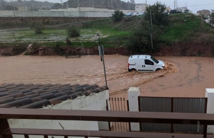 Una furgoneta intenta circular en el agua que ha invadido las calles de la localidad malagueña de Almogía.