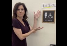 La republicana Nancy Mace colocando un cartel para indicar que los baños del Capitolio han de ser usados según el sexo biológico.