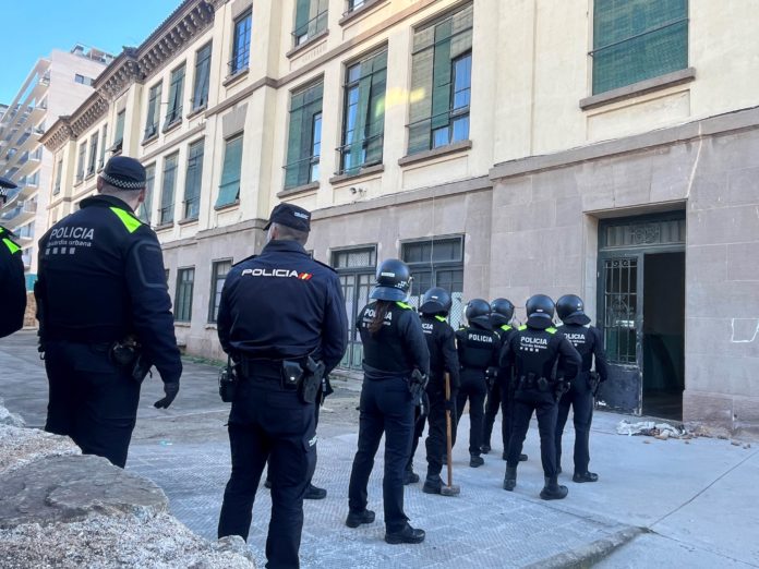 Agentes de la Guardia Urbana de Badalona a las puertas del antiguo colegio Lola Anglada, minutos antes de proceder a la desocupación del mismo.