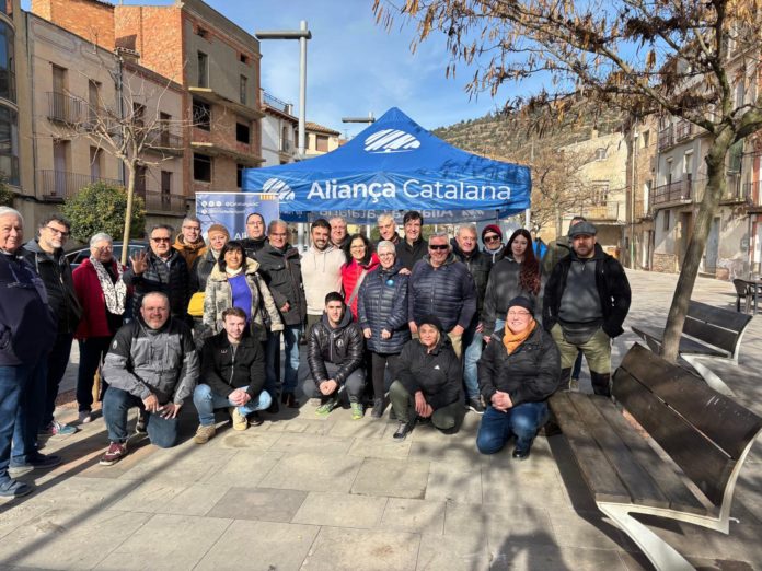 Miembros de Aliança Catalana posan junto a la carpa del partido instalada en Torà este domingo.