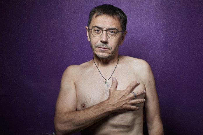 El fundador de Podemos Juan Carlos Monedero posando desnudo delante de un fondo morado.