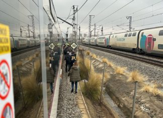 Usuarios de Rodalies caminando por las vías.