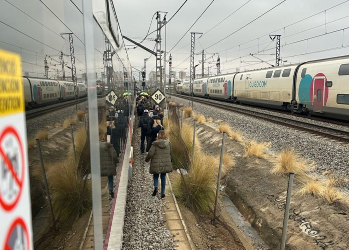 Usuarios de Rodalies caminando por las vías.